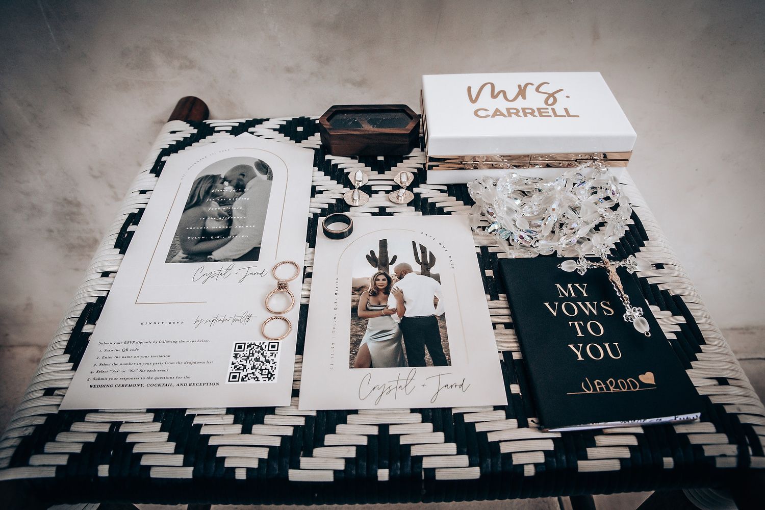 Wedding stationery and invitation suite displayed on black and white geometric pattern with modern design elements.