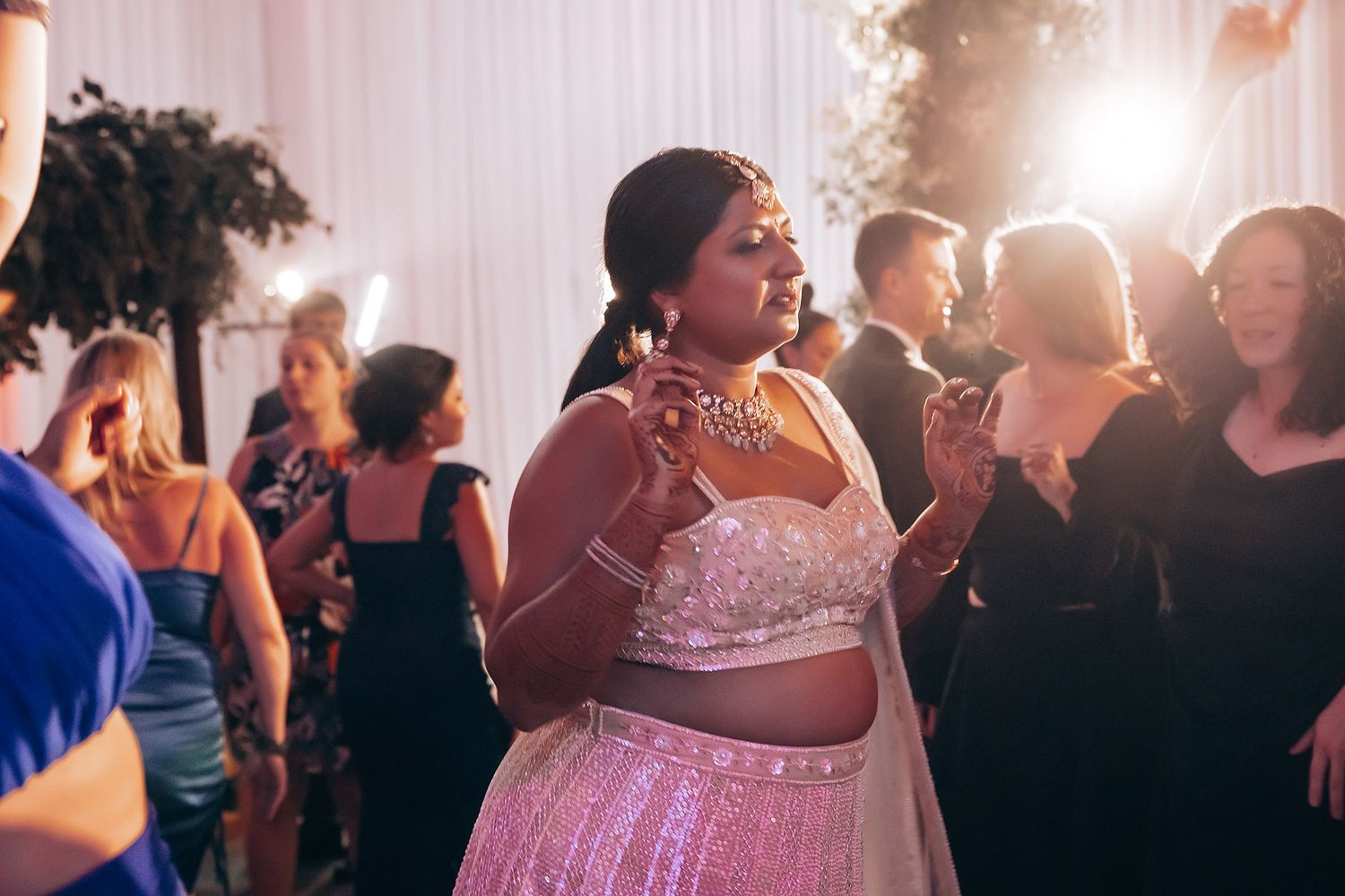 Wedding reception dance floor filled with guests celebrating in formal attire.