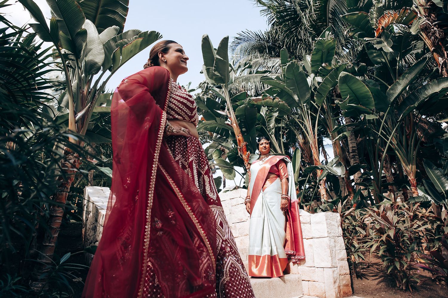 Festive outdoor wedding celebration with guests in colorful traditional Indian attire.
