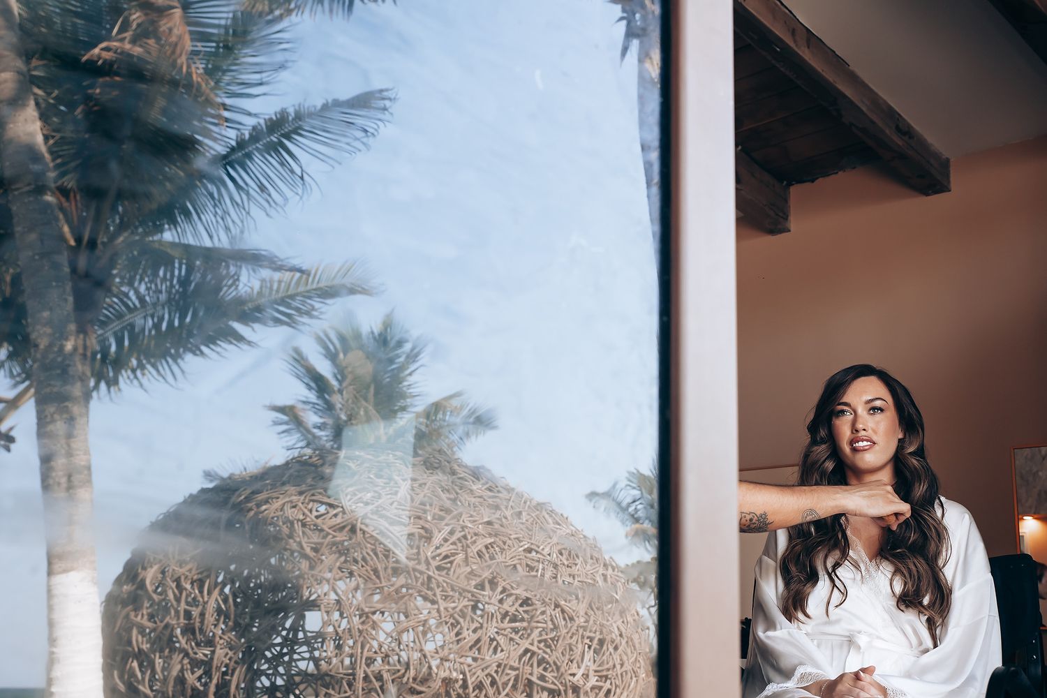 A beachside wedding ceremony setup with white chairs and palm trees swaying in the tropical breeze.