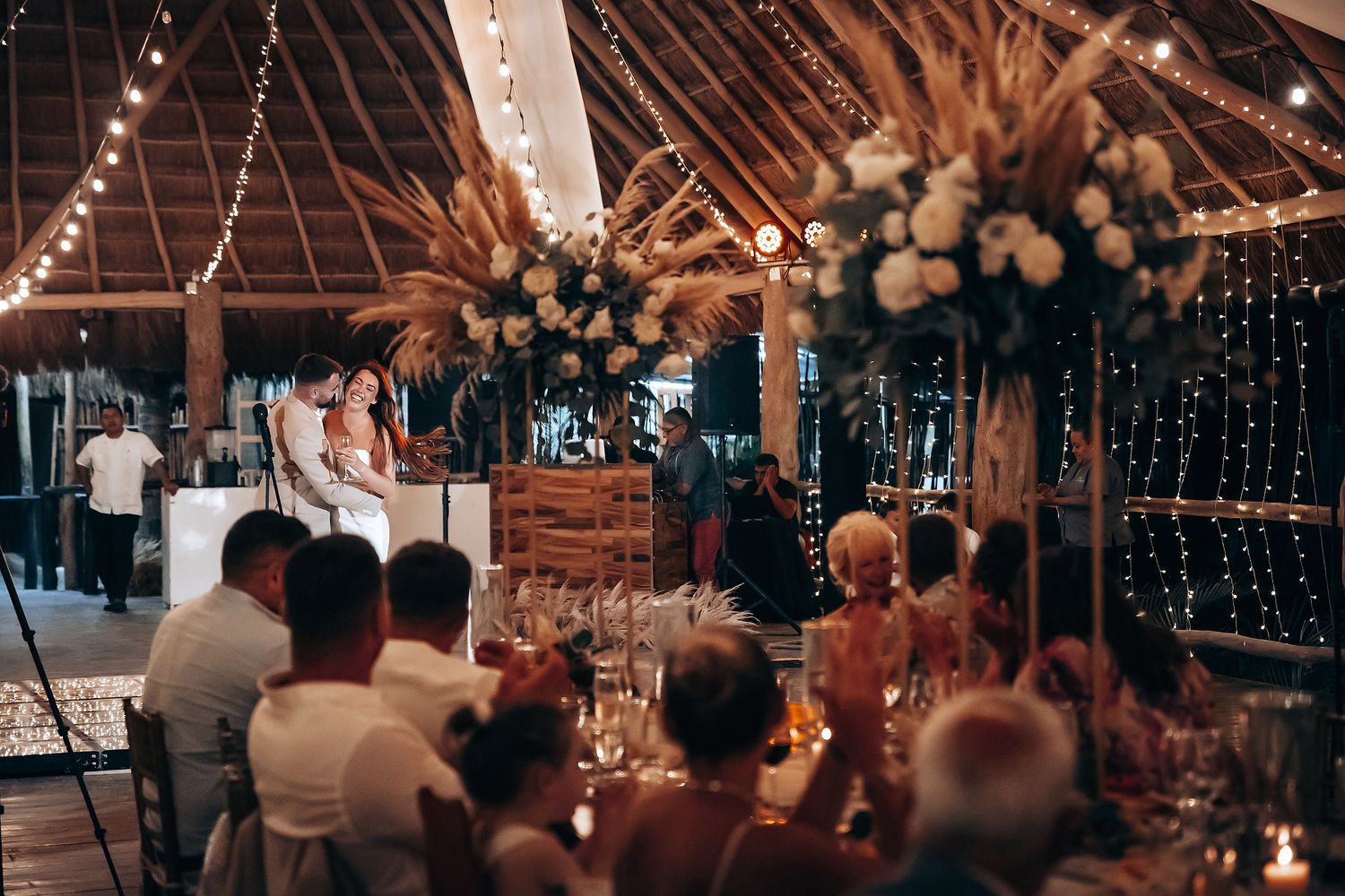 Rustic barn wedding reception with string lights and white floral decorations creating a romantic ambiance.