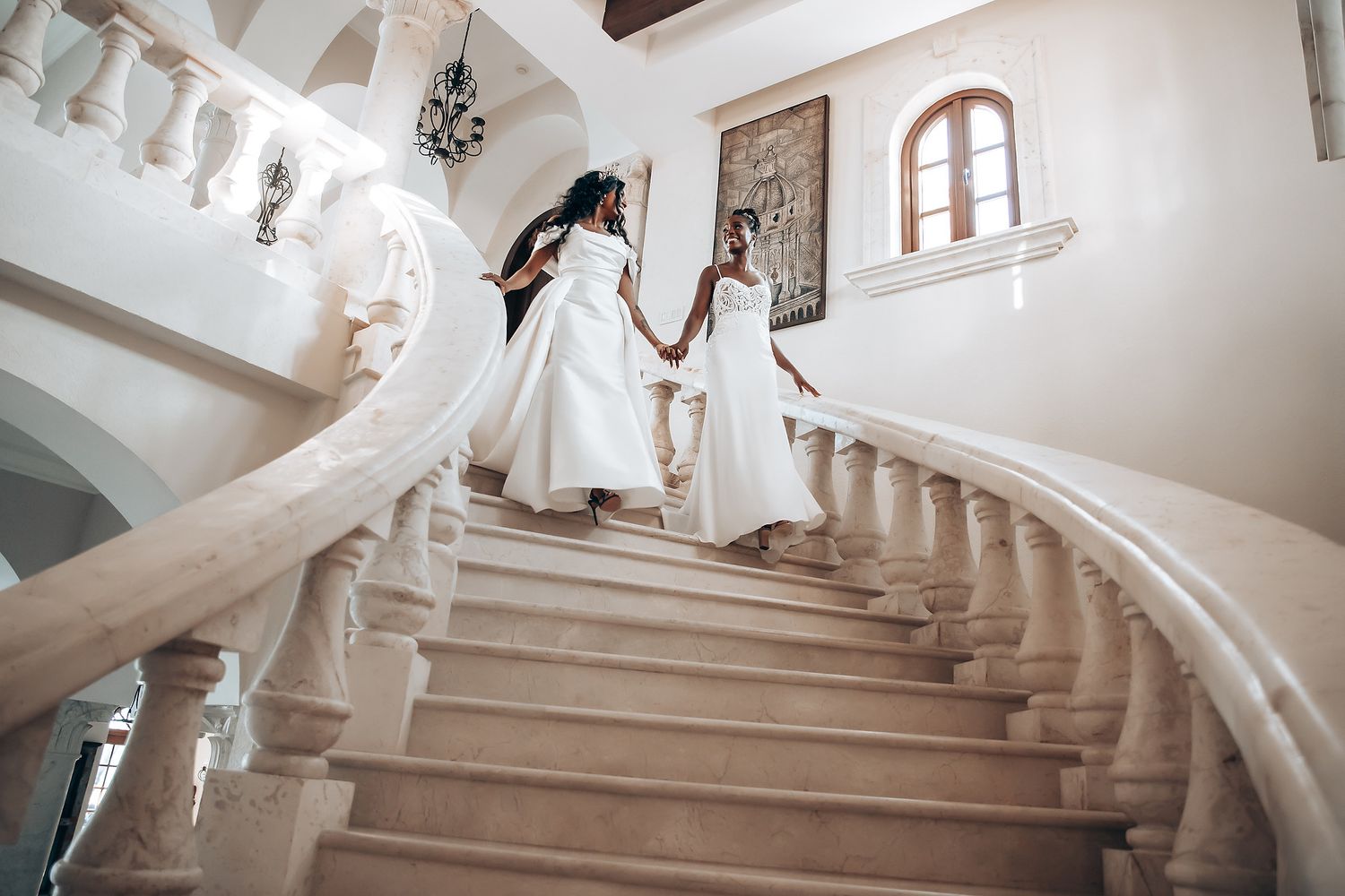 Elegant wedding photos on a grand white marble staircase with decorative railings.
