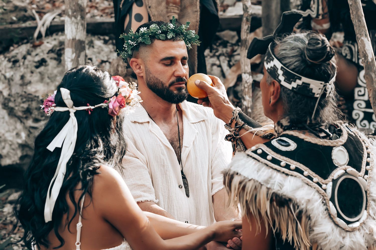 Traditional blessing ceremony with smoke and feathers in forest setting.