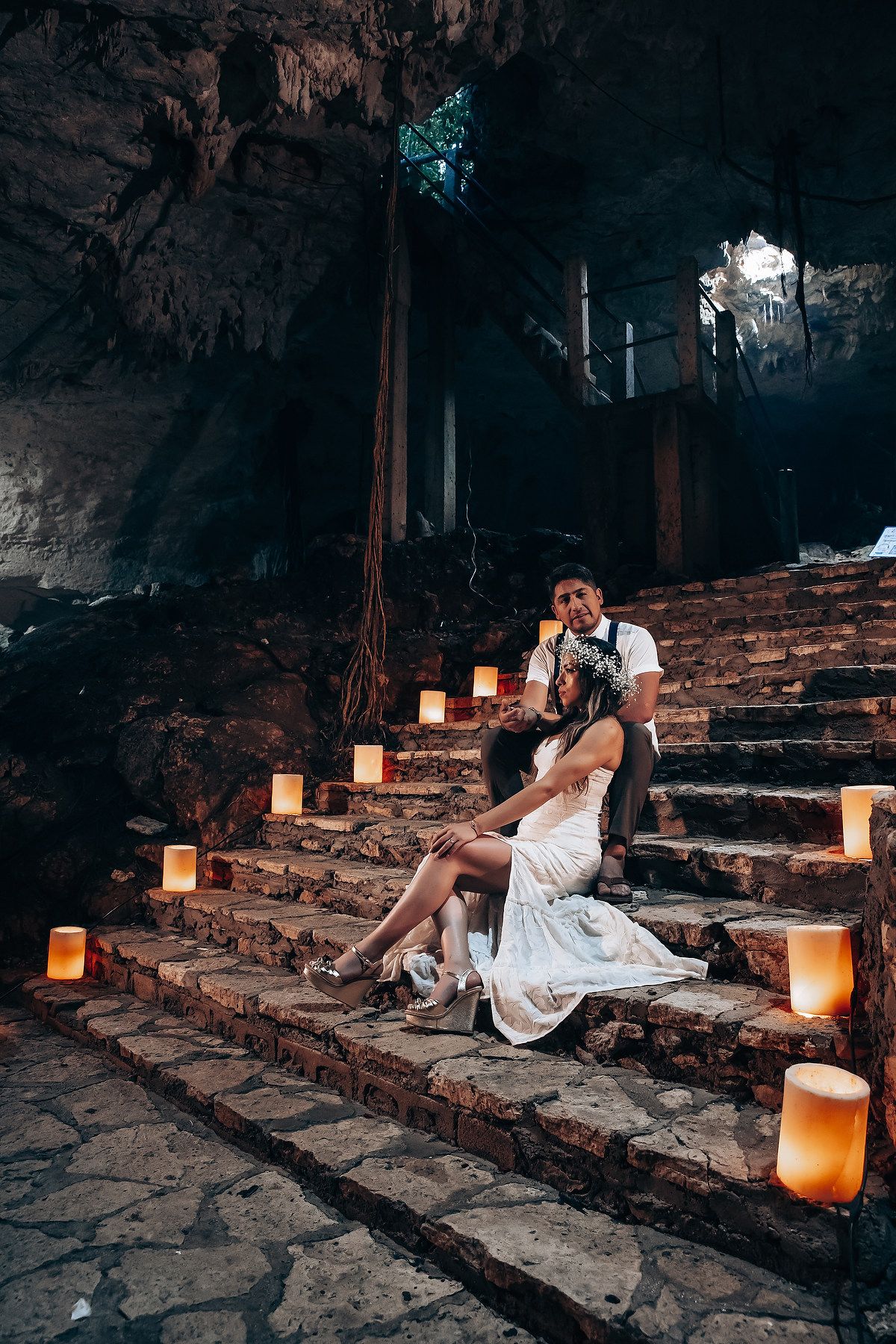 A stone stairway illuminated by warm candlelight creates an ethereal ambiance in a historic setting.