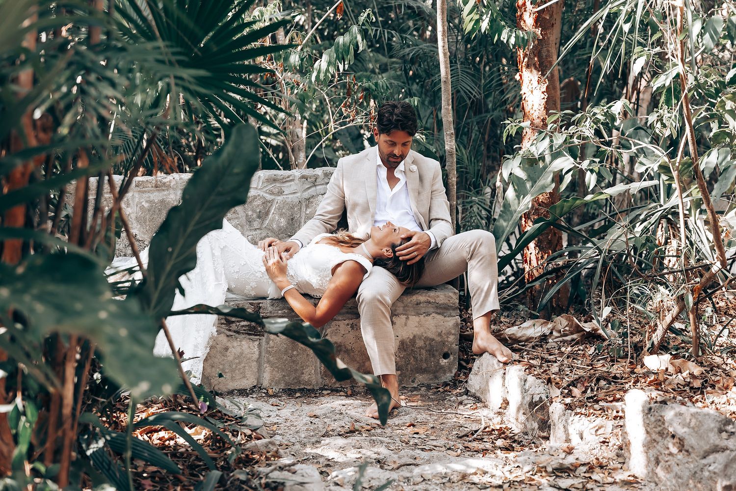 Wedding couple shares intimate moments during an outdoor tropical photoshoot among agave plants.
