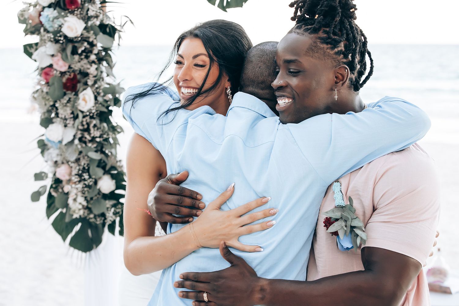 A couple embraces in a scenic outdoor setting with flowers.
