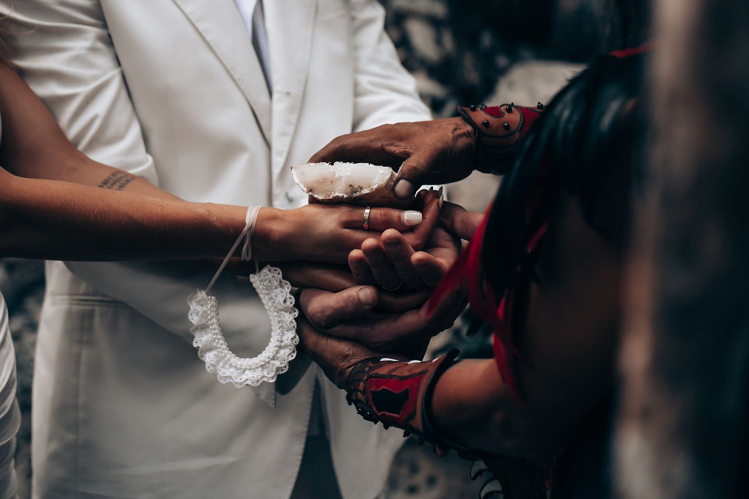 Close-up of hands during a traditional wedding ring exchange ceremony.