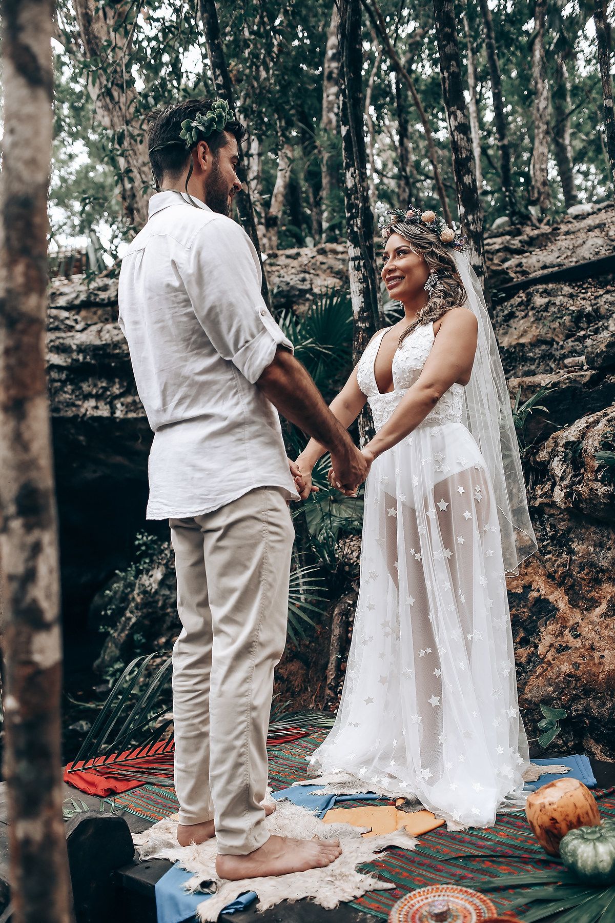 A couple shares an intimate moment during their outdoor forest wedding ceremony.