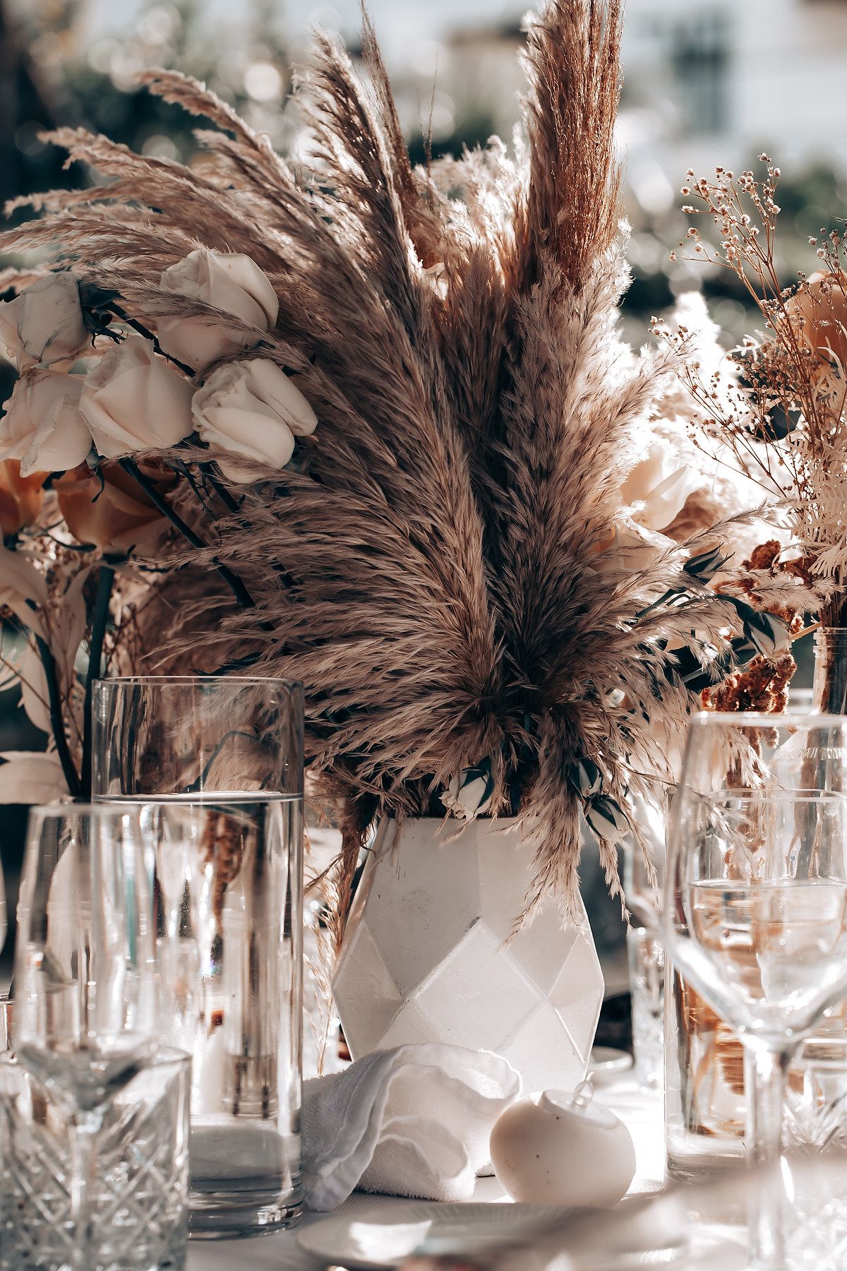 An elegant wedding centerpiece with pampas grass and dried flowers in neutral tones.