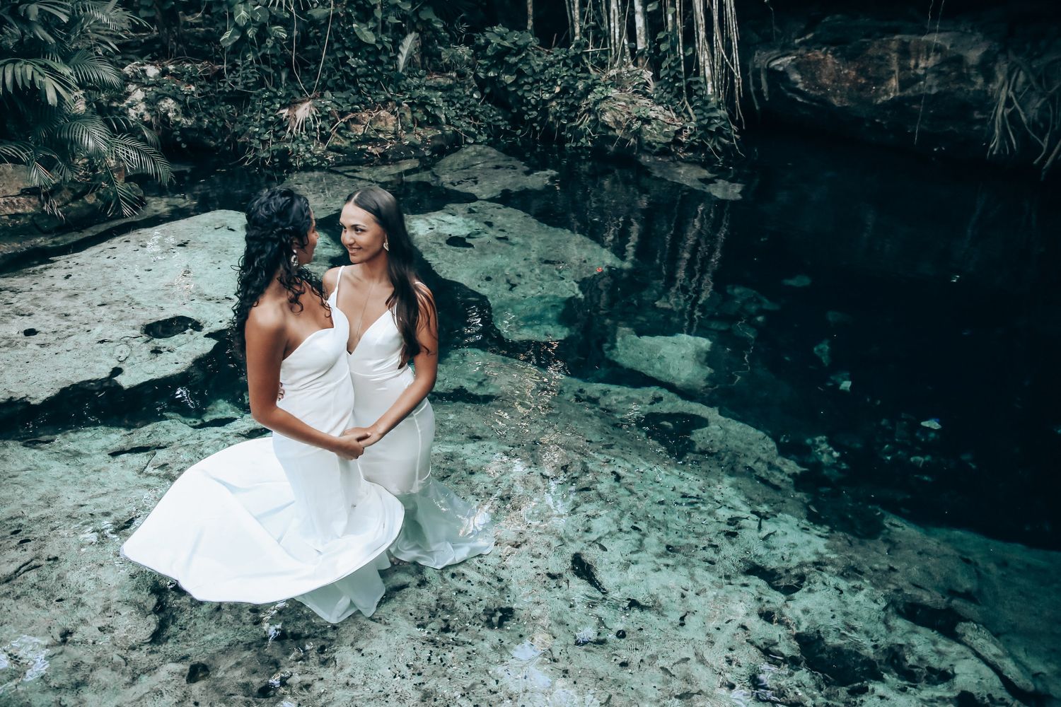 Elegant wedding photography session on limestone rocks beside a crystal clear cenote.