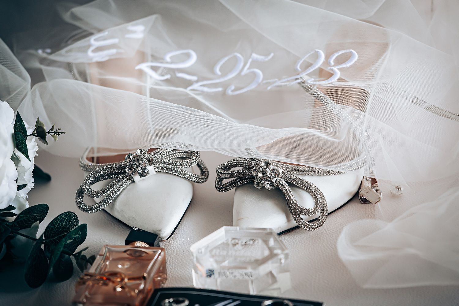 Wedding details including veil and date text overlay in soft focus.