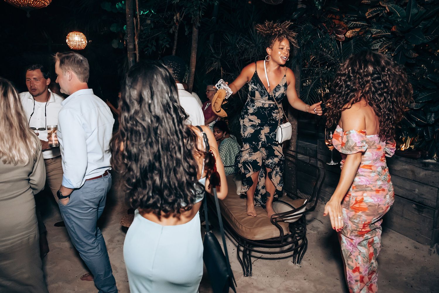 Wedding guests dancing and celebrating at an evening reception party.