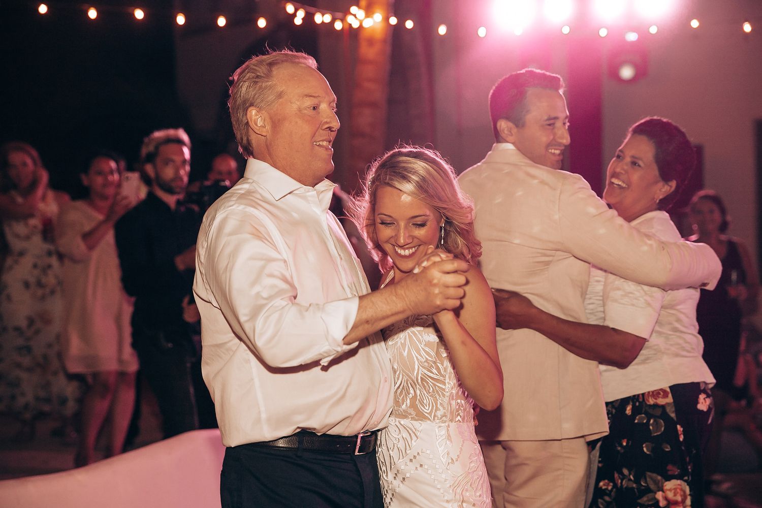 Wedding reception dance with string lights and warm lighting creating romantic atmosphere.