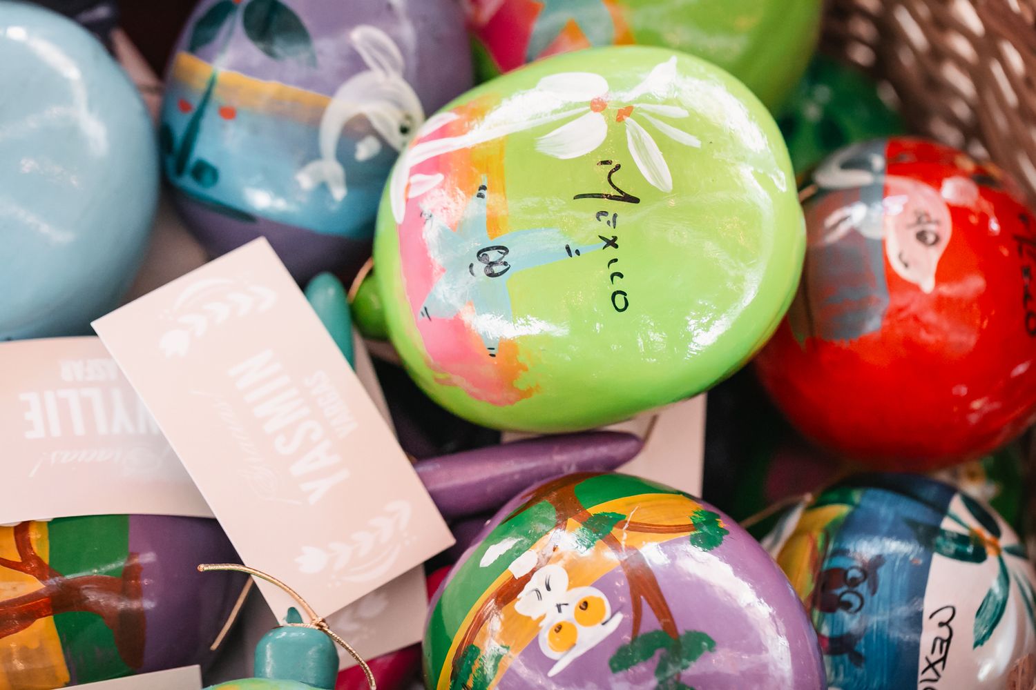 Colorful hand-painted Easter eggs with floral designs and name tags displayed together in a festive arrangement.