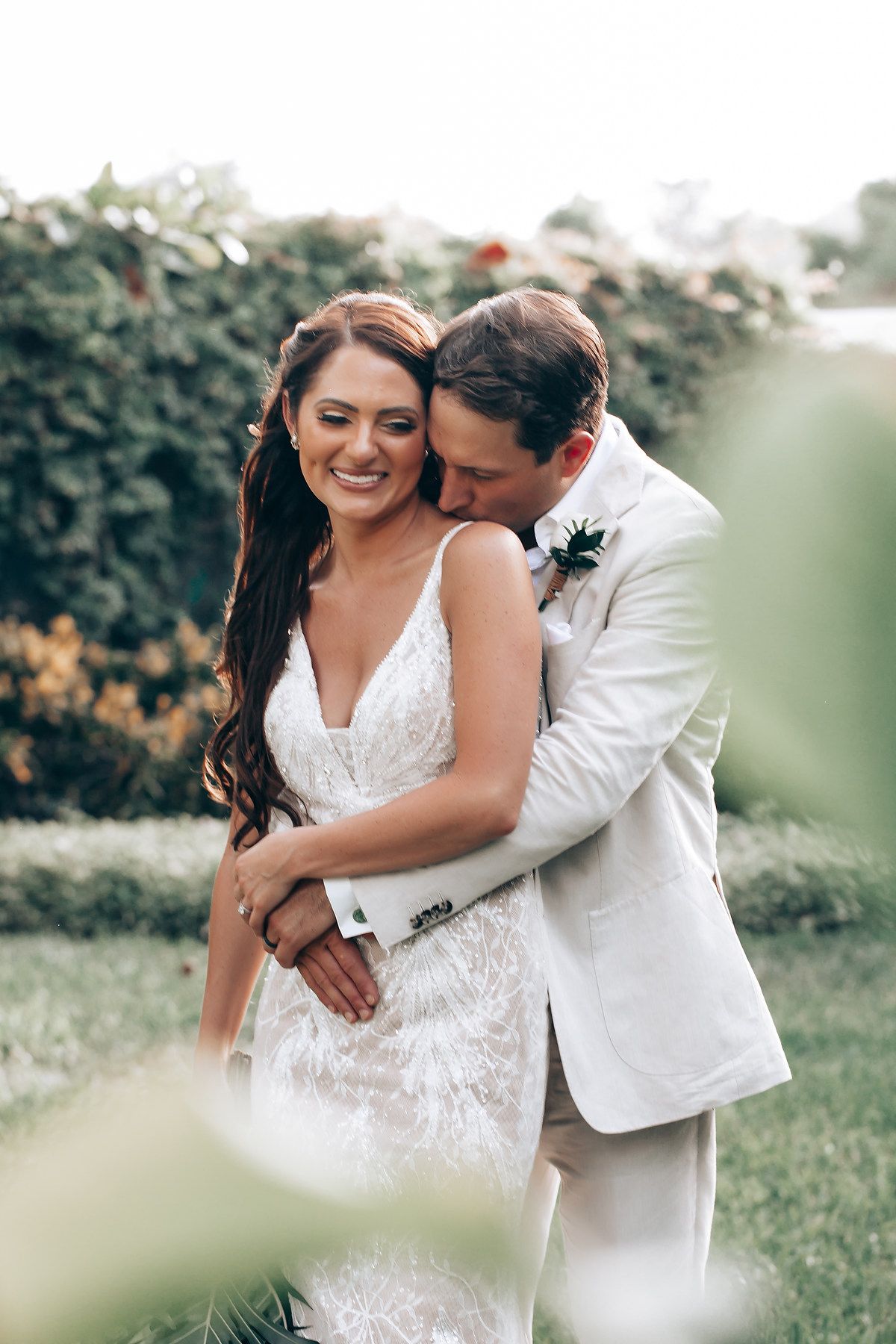 Intimate moment between newlyweds in garden setting with soft natural lighting.