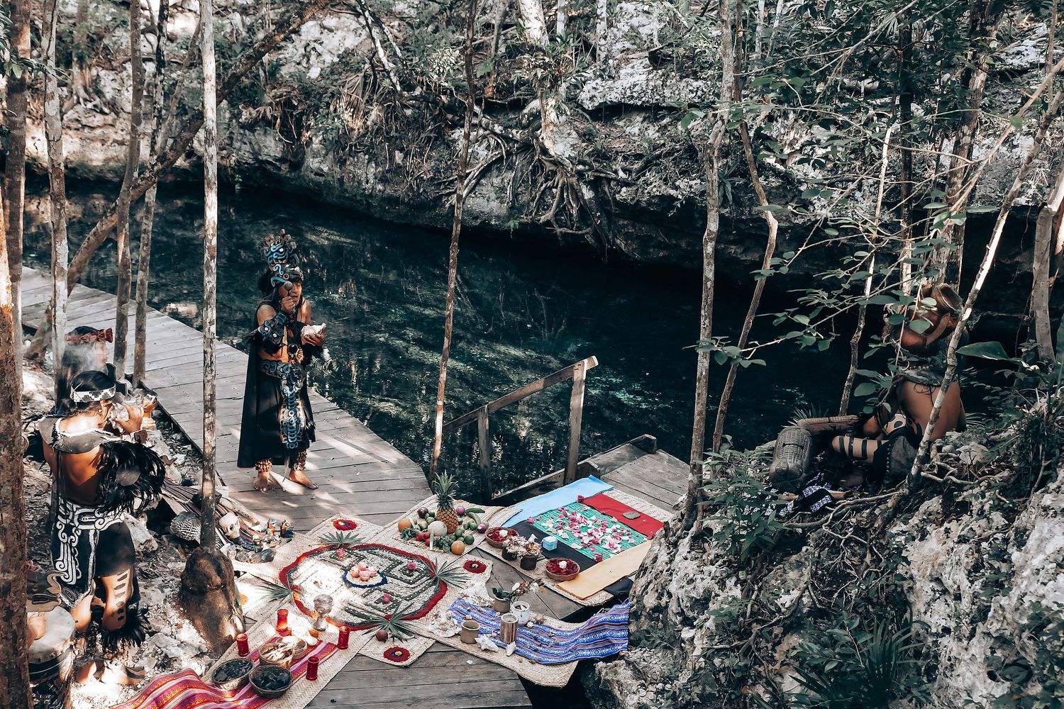 Traditional ceremony participants gather under trees in an outdoor setting for a spiritual ritual.
