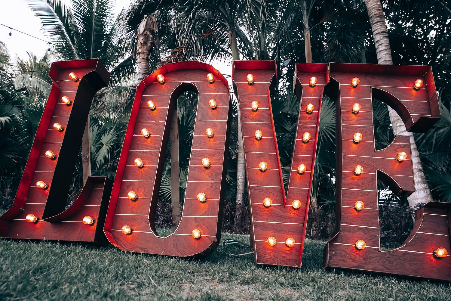 Large red illuminated marquee letters spelling 'LOVE' displayed at an outdoor event.