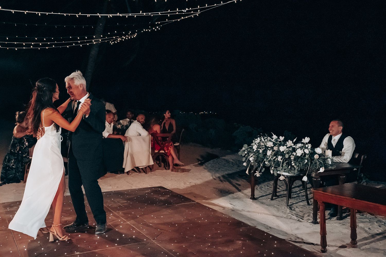 Evening wedding reception with string lights creating ambient atmosphere.