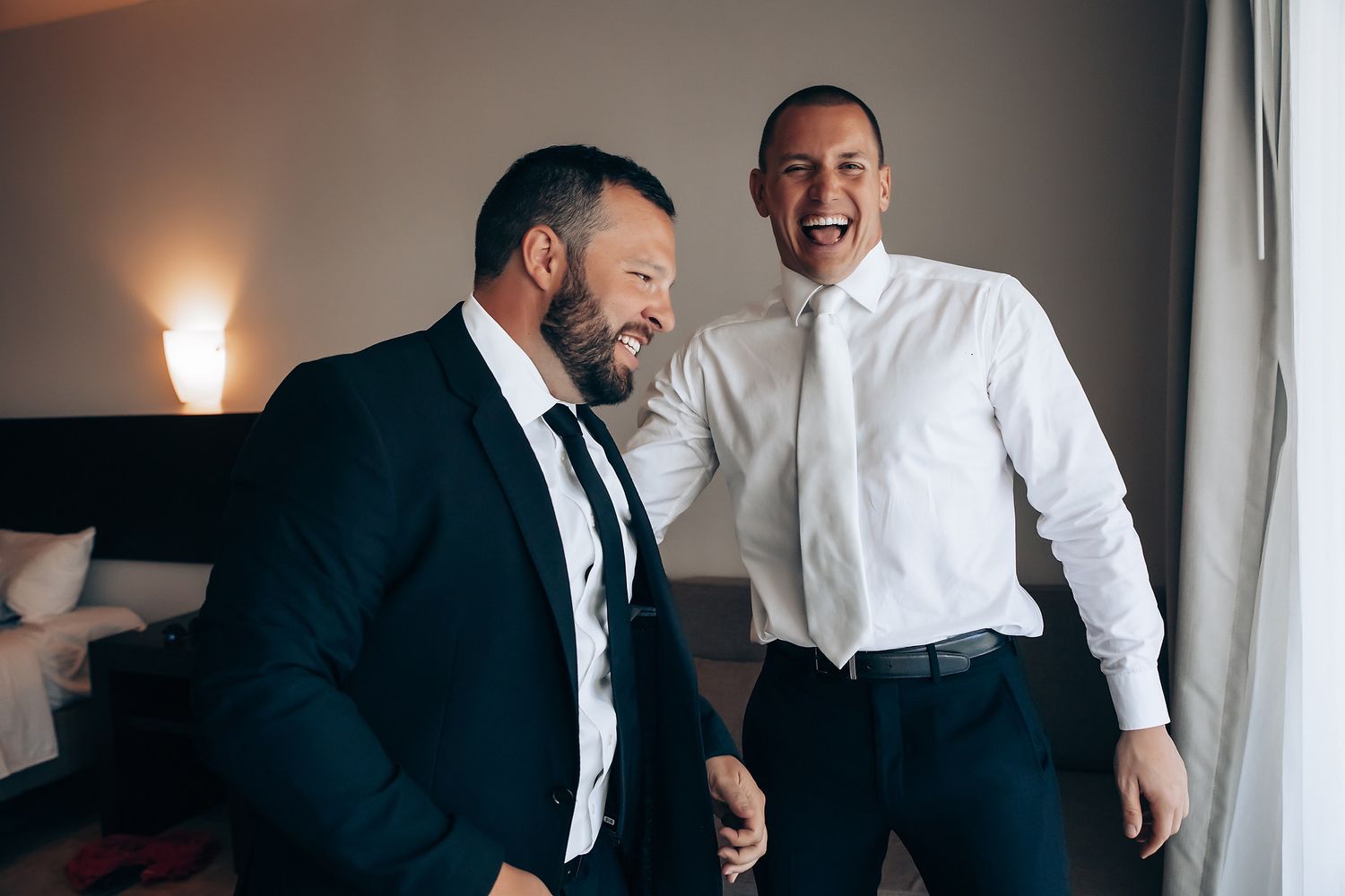 Wedding party members sharing laughs and candid moments while getting ready.