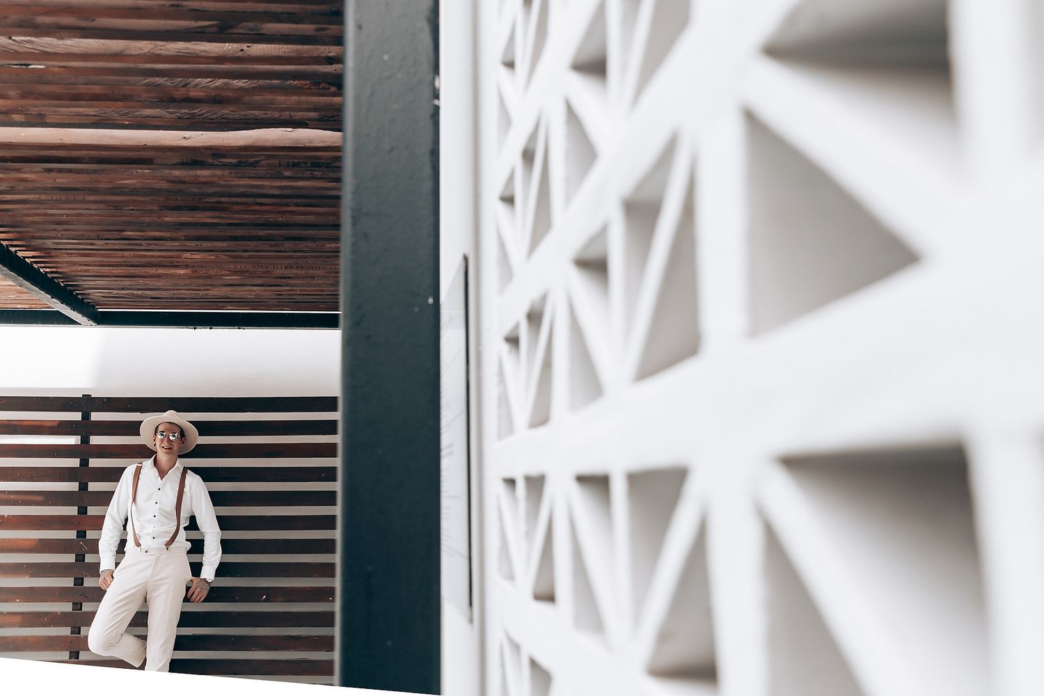 Modern geometric white wall pattern with diagonal lines and shadows creating an architectural texture.