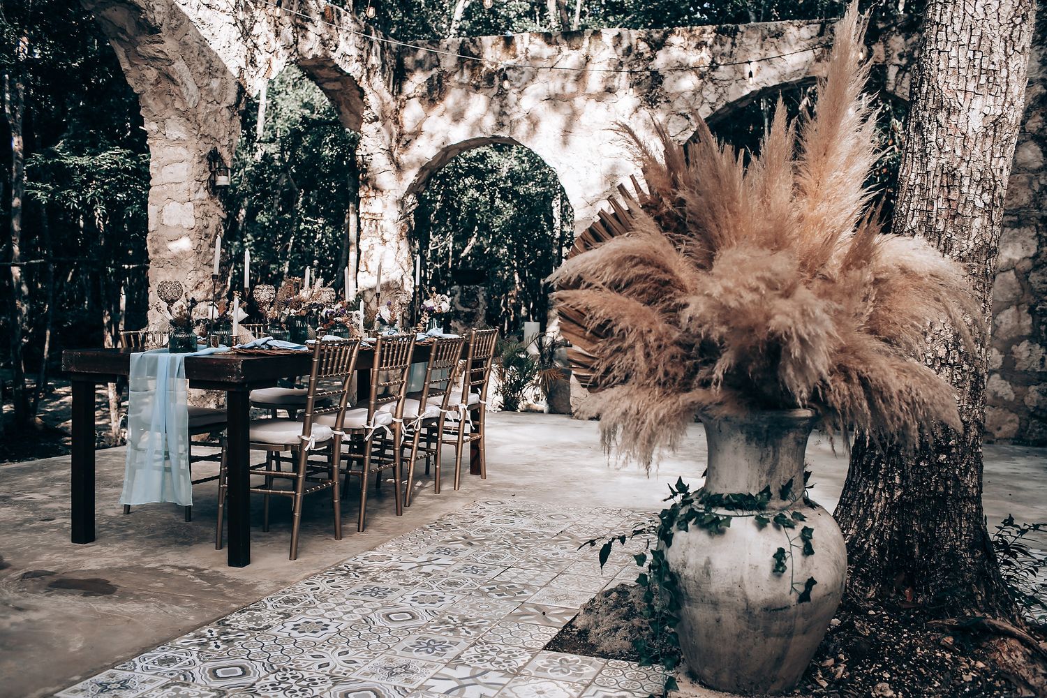 A romantic outdoor wedding ceremony setup in a wooded area with rustic decorations and natural lighting.