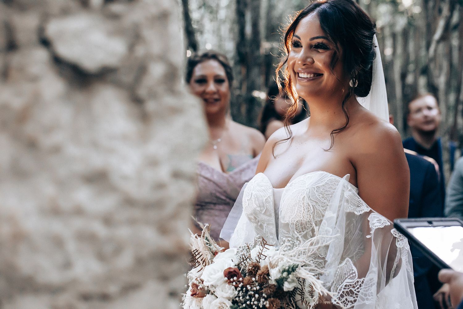 Wedding ceremony attendees celebrating in an outdoor garden setting.