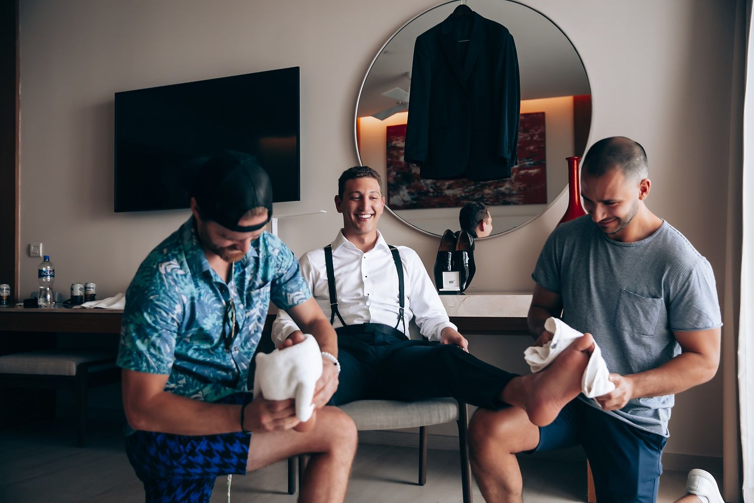 Three people sitting together in a room getting ready for a formal event.