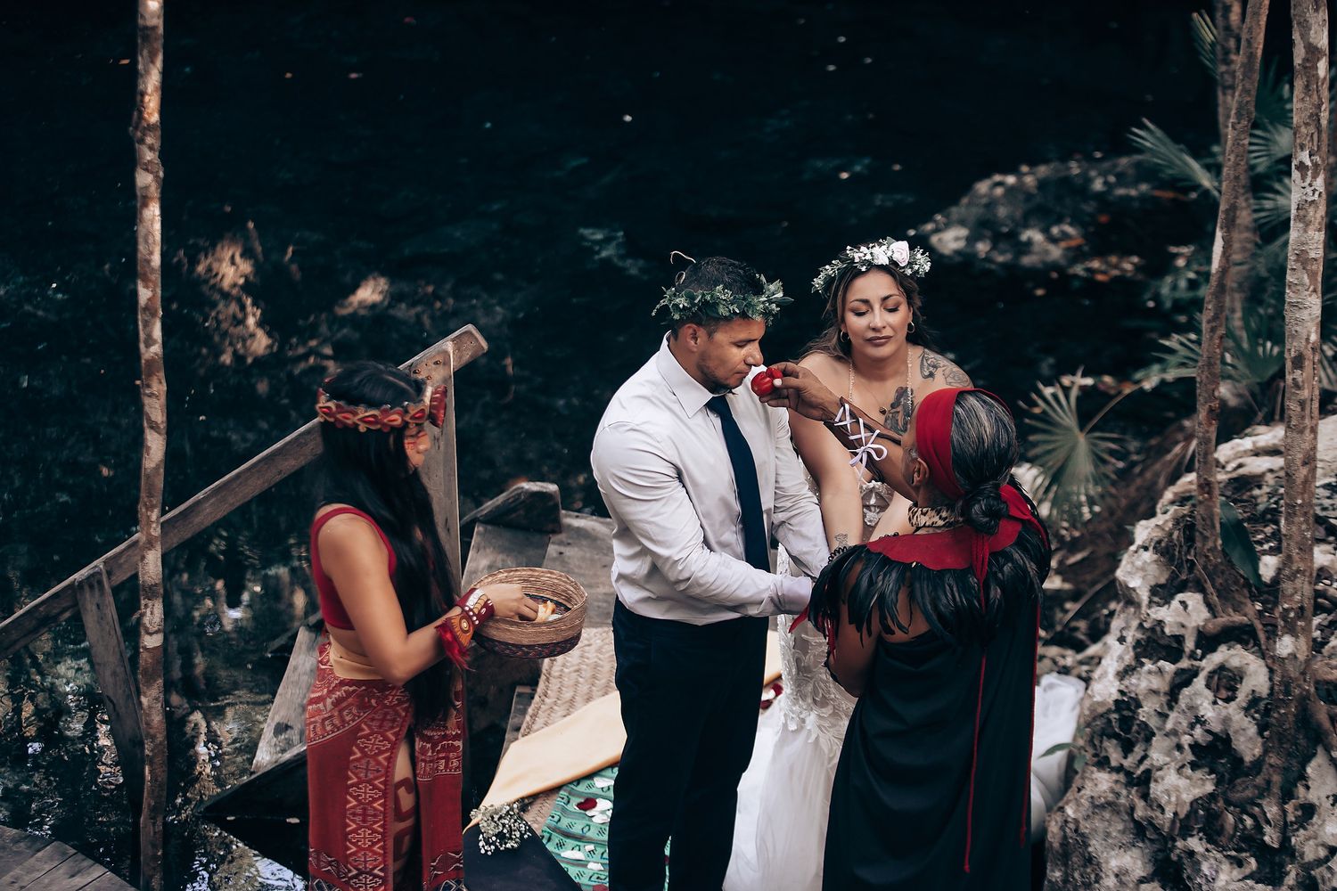 A magical wedding moment captured in a limestone cave with filtered sunlight creating dramatic shadows.