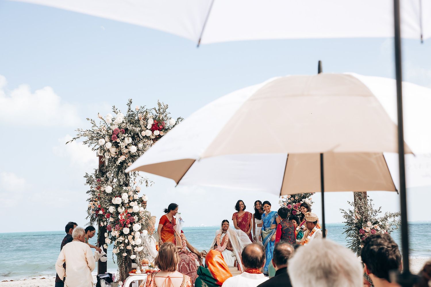 Beachside wedding ceremony setup with white canopy and chairs overlooking the ocean.