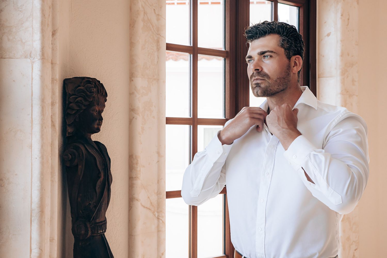 A collage of four photos showing someone in a white button-down shirt adjusting their collar and cuffs.