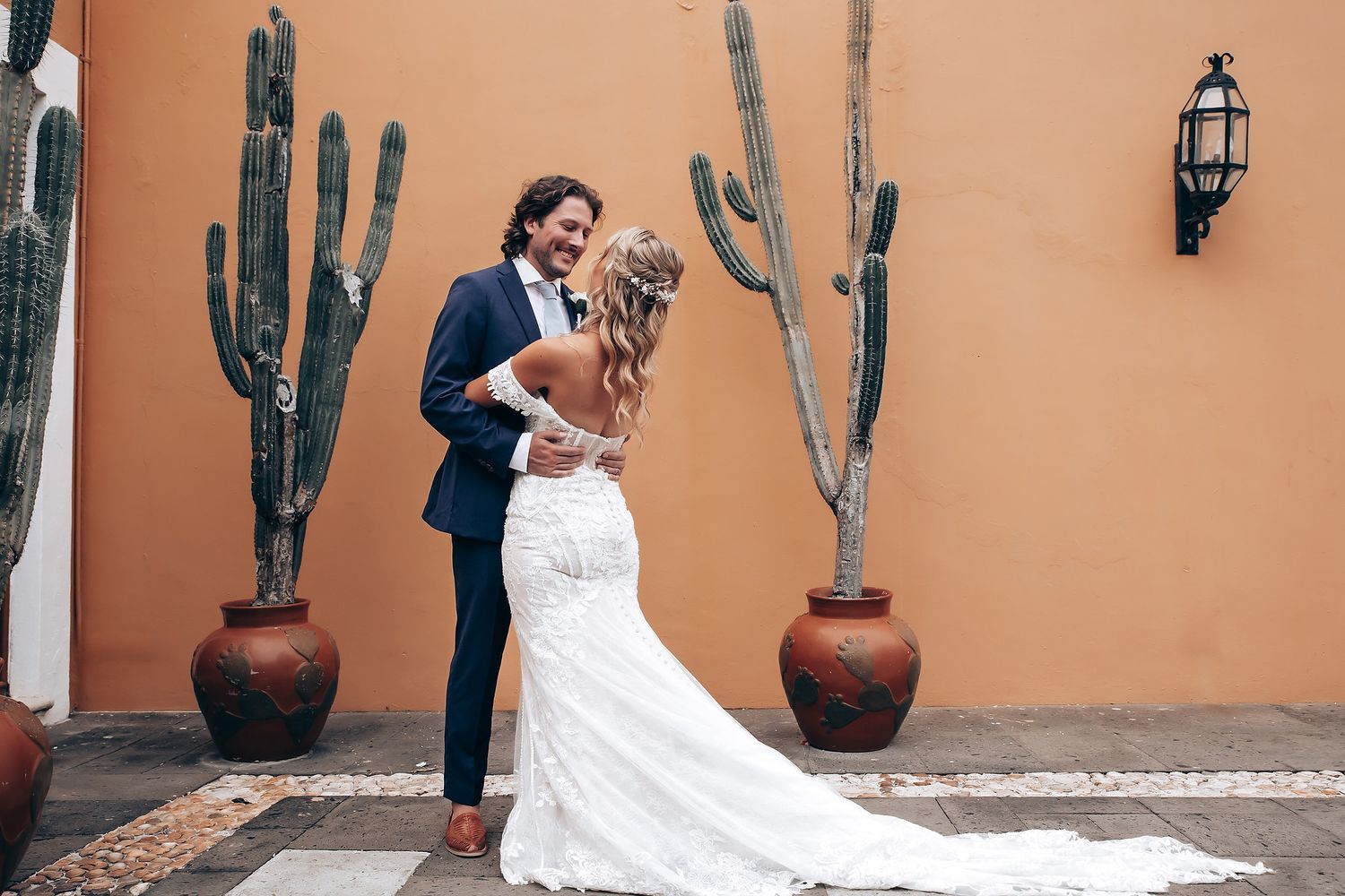 Desert-themed wedding venue with terra cotta walls and potted cacti creating an intimate setting.
