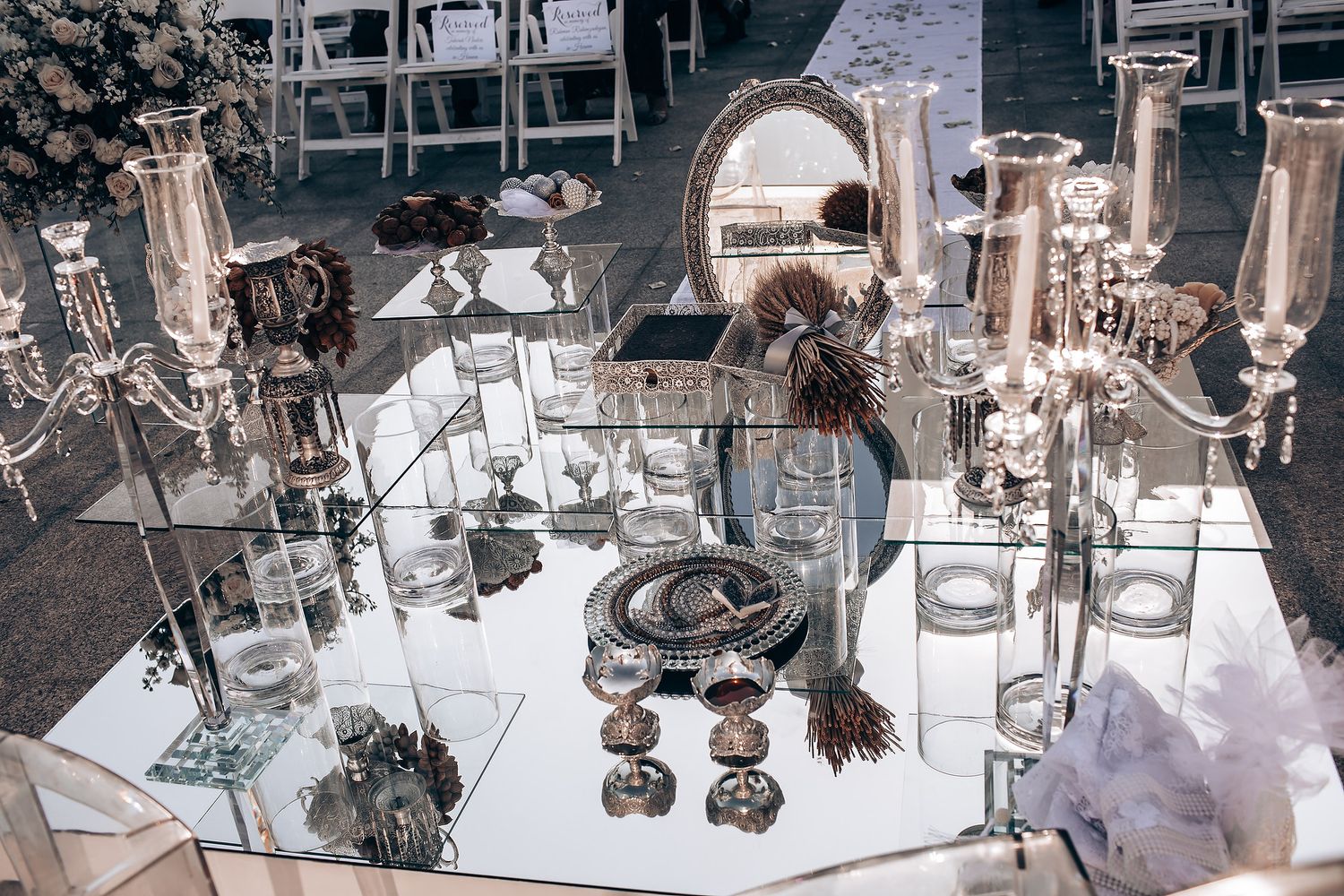 Luxurious mirrored wedding decor display featuring ornate silver candelabras and crystal accents.