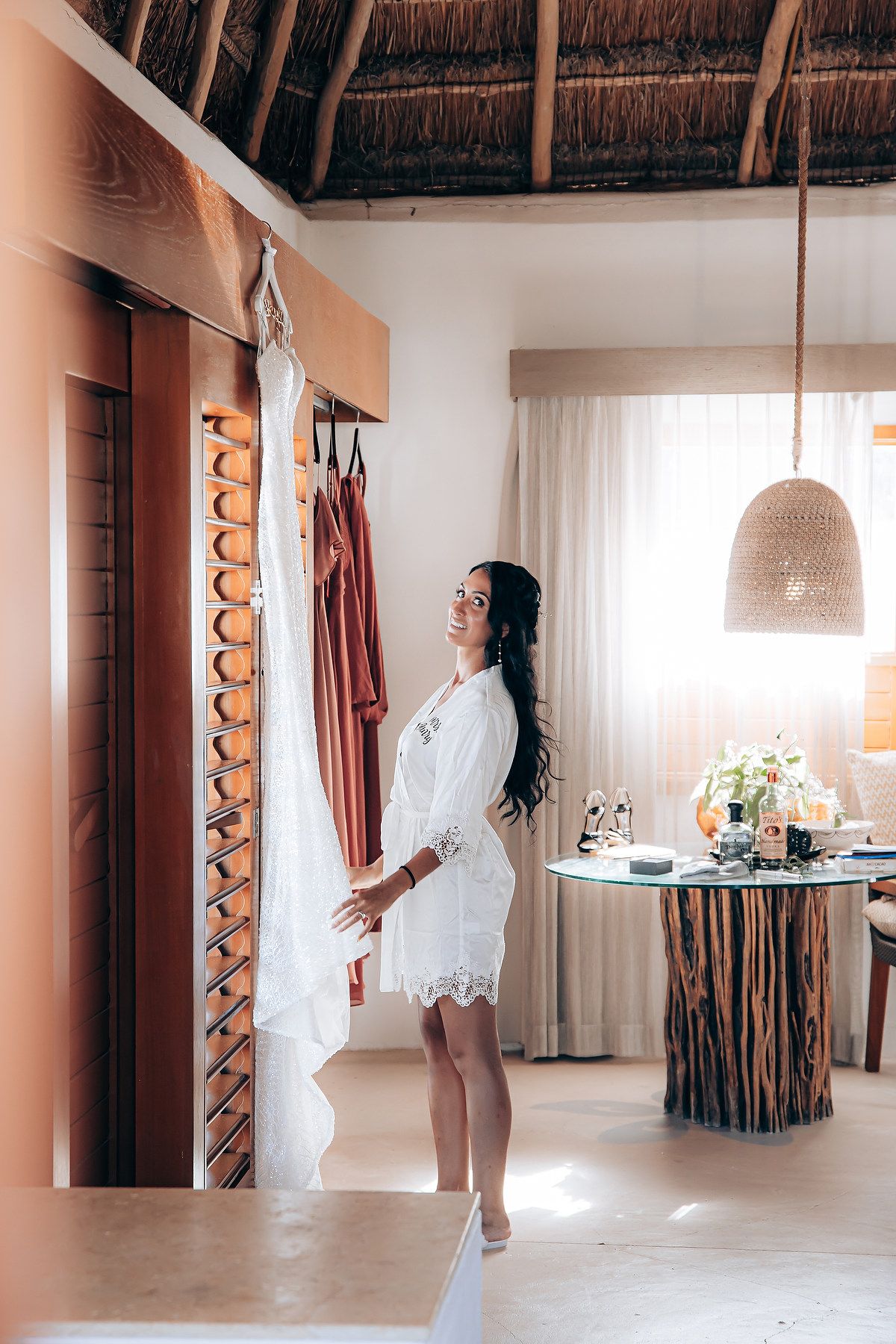 Bright interior of a luxury beach villa with thatched roof and modern bohemian decor.