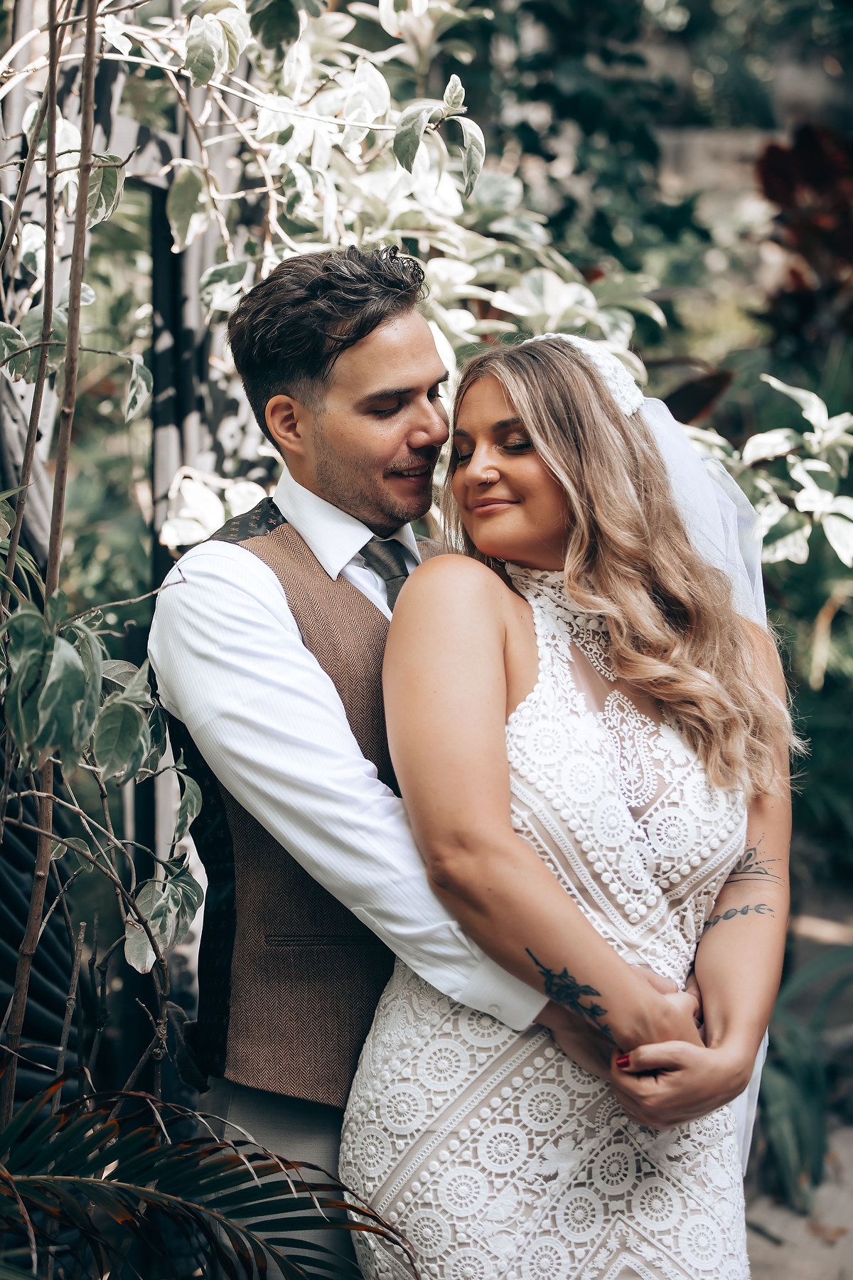 Intimate wedding portraits showing tender moments between newlyweds in a garden setting.