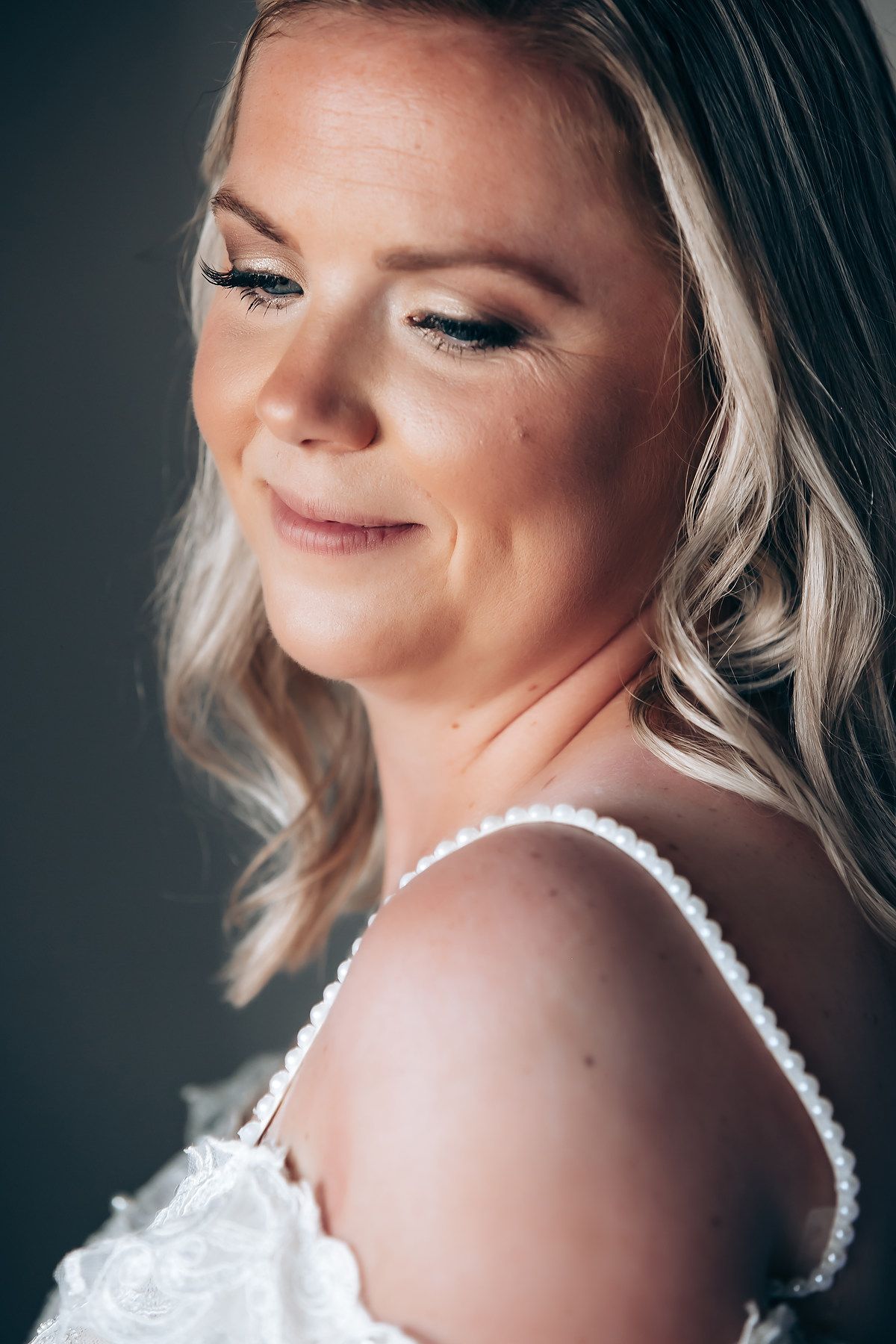 Close up portrait showing delicate makeup and soft lighting in a romantic bridal style.