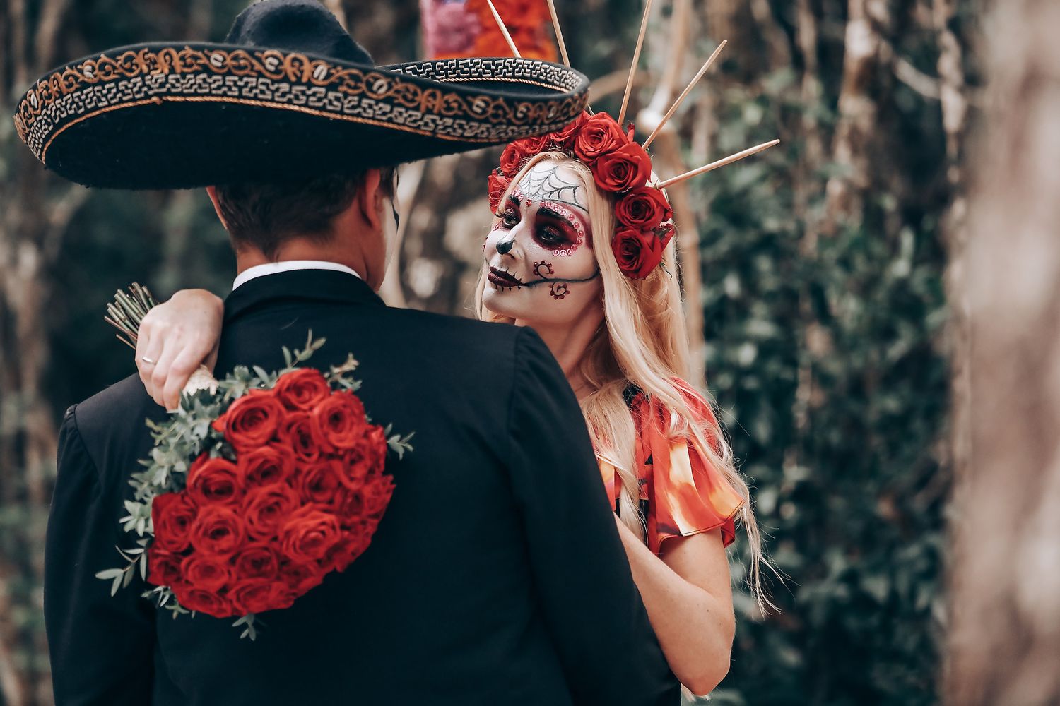 Close-up details of ornate headpiece with red roses against dark winter attire.