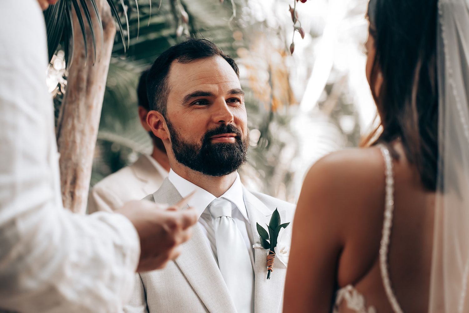 Intimate wedding ceremony moment captured in a tropical outdoor setting.