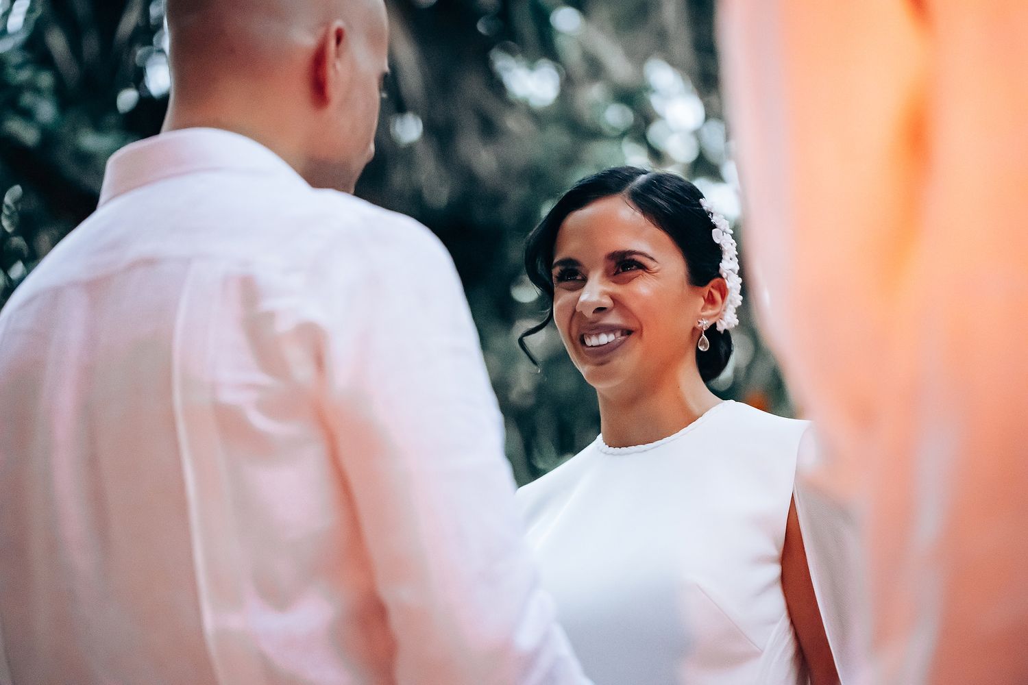 Joyful wedding celebration moment against a coral-colored backdrop.