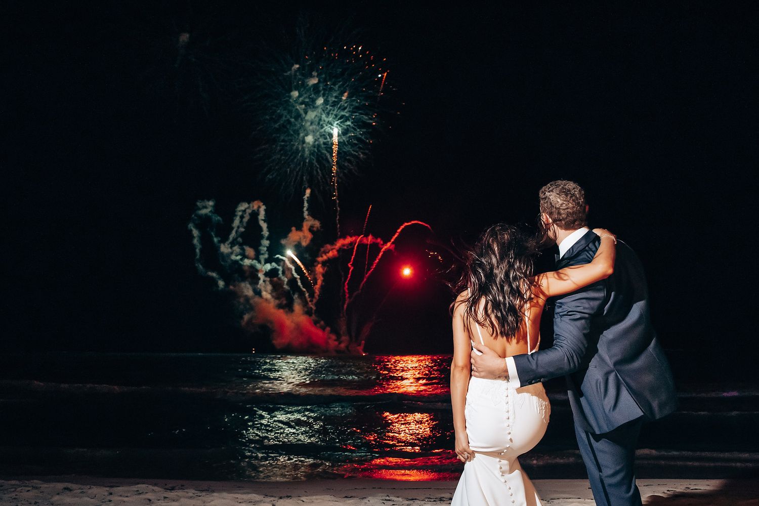 Romantic nighttime dance scene with red lighting and palm trees.