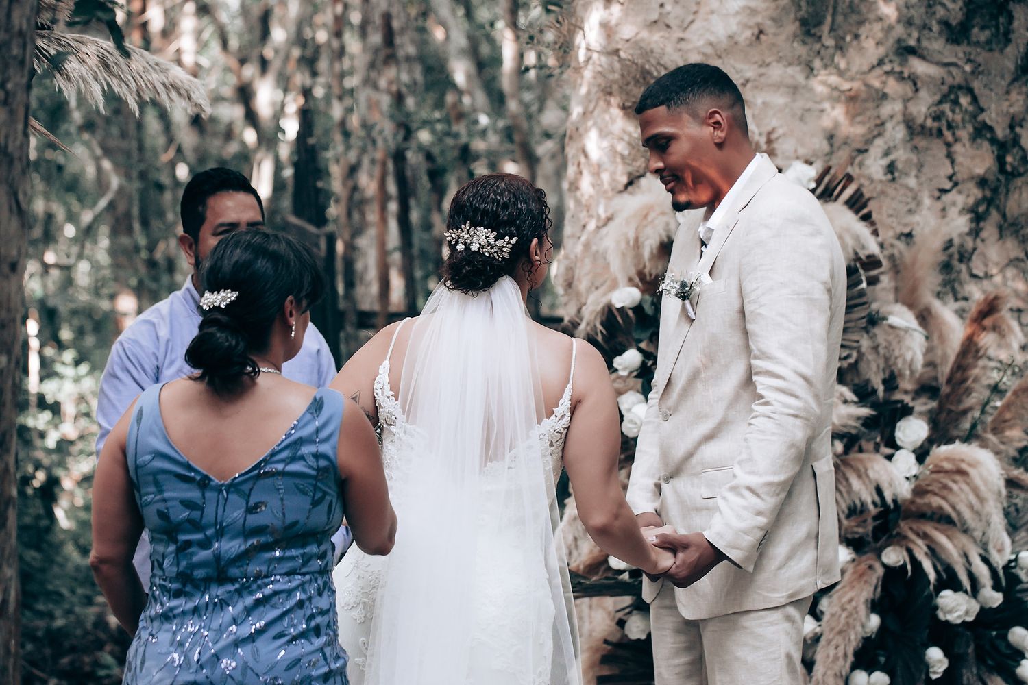 An intimate forest wedding ceremony with attendees gathered in a natural setting.