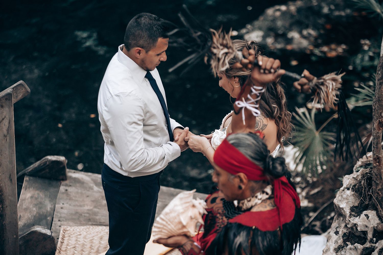 A traditional wedding ceremony takes place outdoors with participants gathered around a ceremonial table.