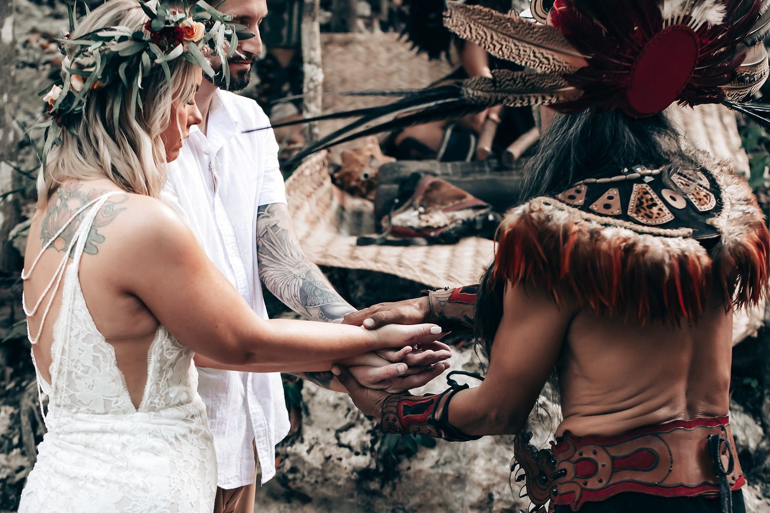 Traditional ceremony elements displayed with red flowers and natural decorations in cave setting.