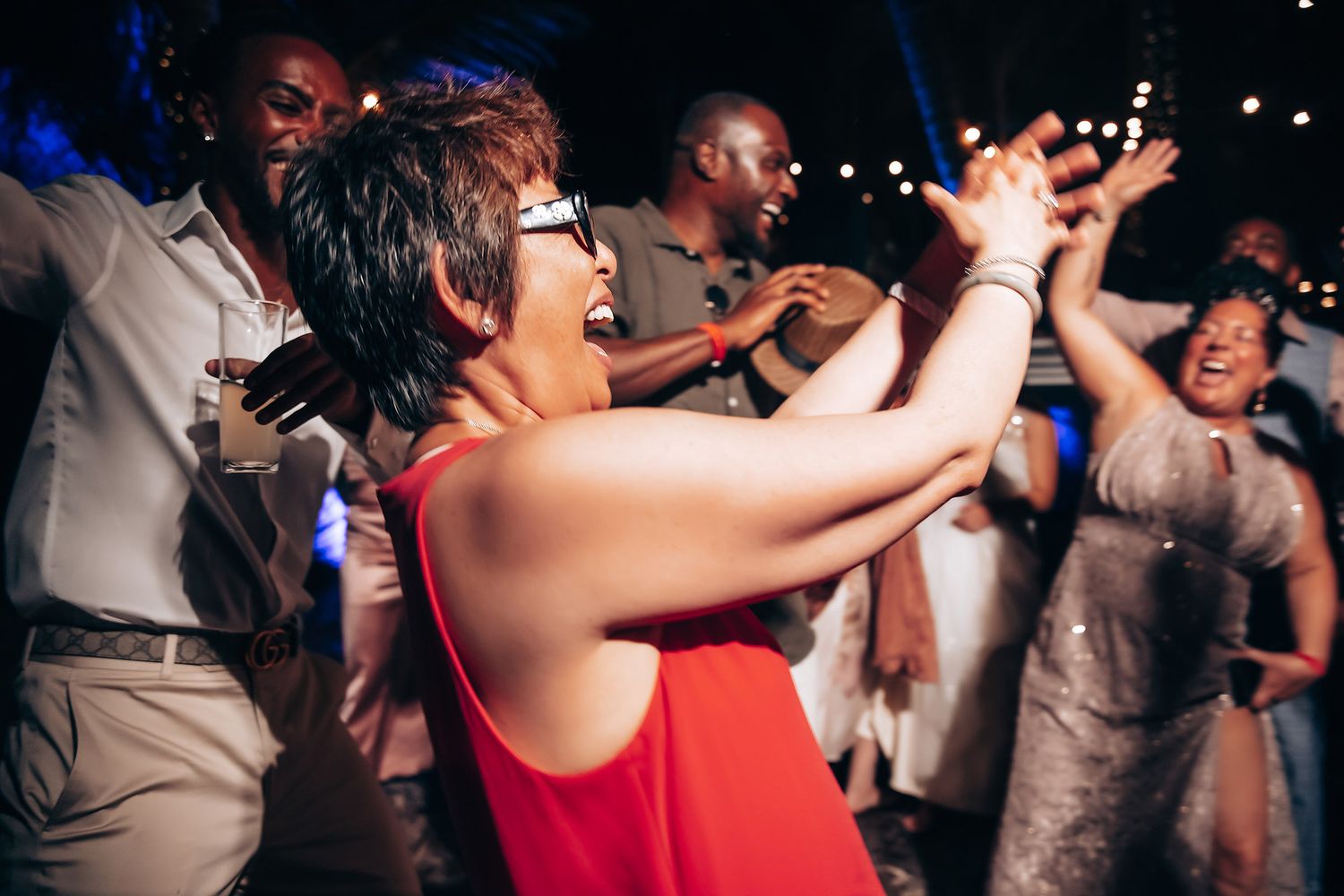 Wedding guests dancing joyfully at a lively evening reception.
