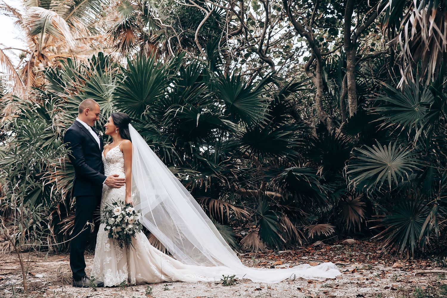 Romantic wedding portraits taken among lush tropical garden setting.