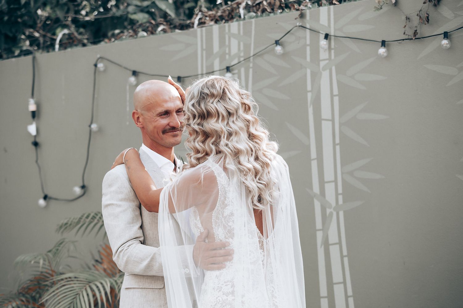A romantic moment captured in an indoor setting with artistic wall decorations.