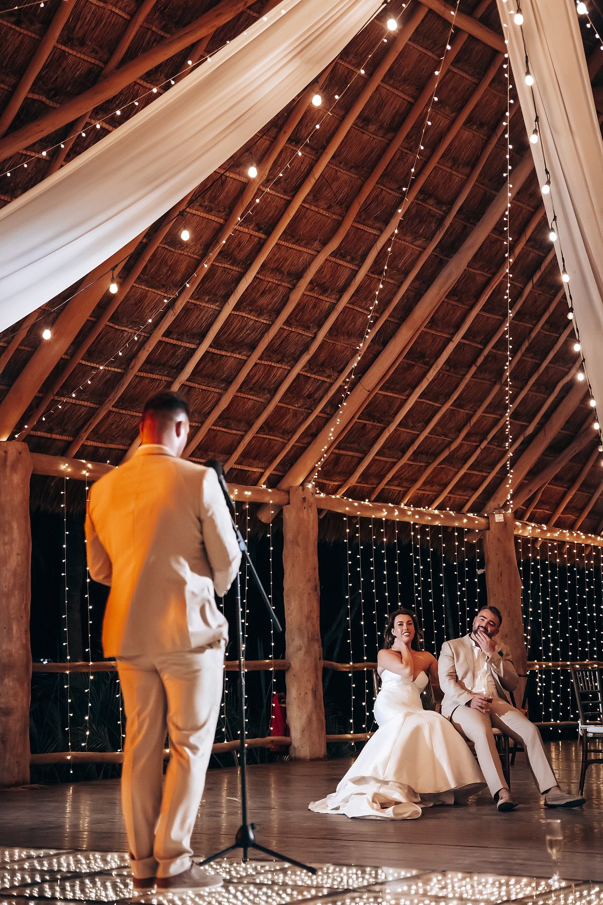 A sequence of dance floor moments at a rustic barn wedding reception with twinkle lights and white drapes.