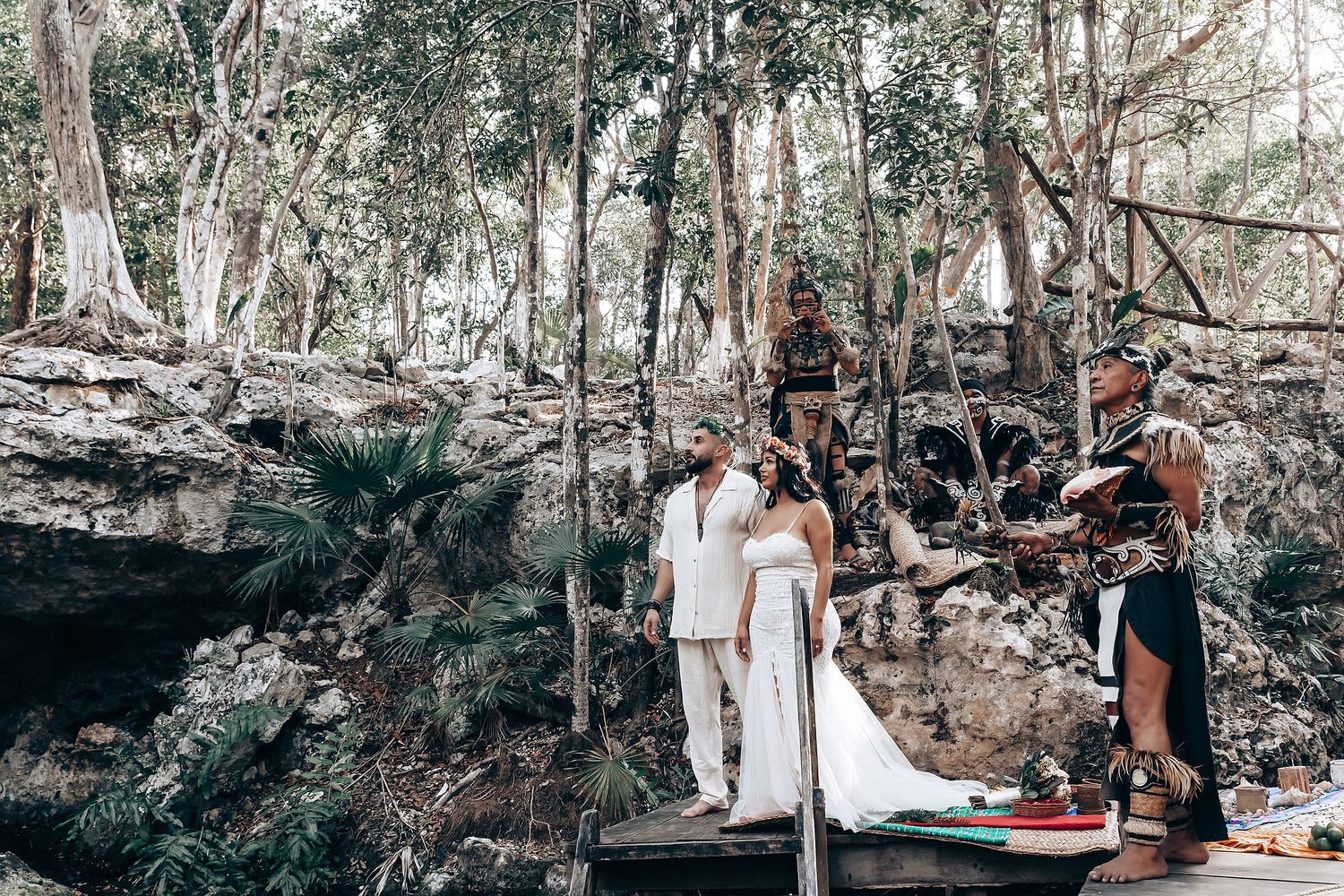 Natural outdoor wedding venue with wooden platforms and lush forest surroundings.