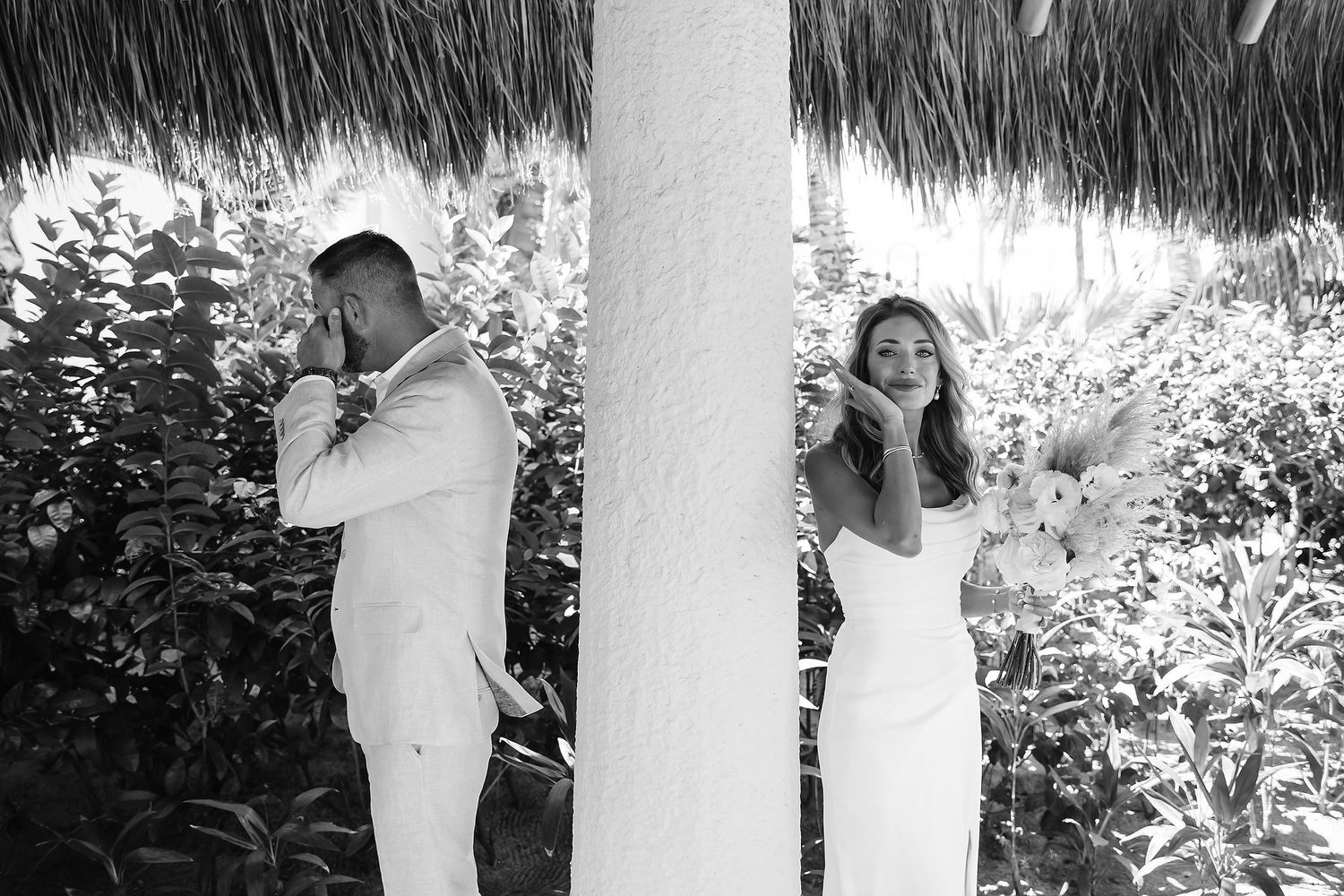 A couple is standing together in a tropical garden.