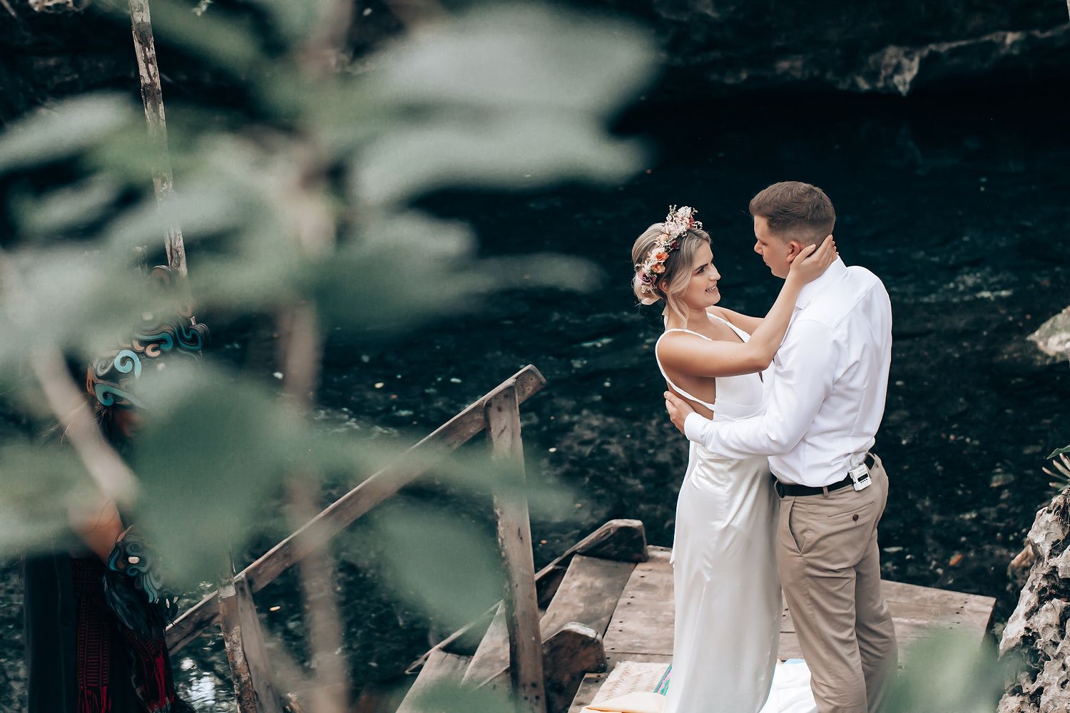 A couple shares an intimate dance moment in a natural outdoor setting with trees in the background.