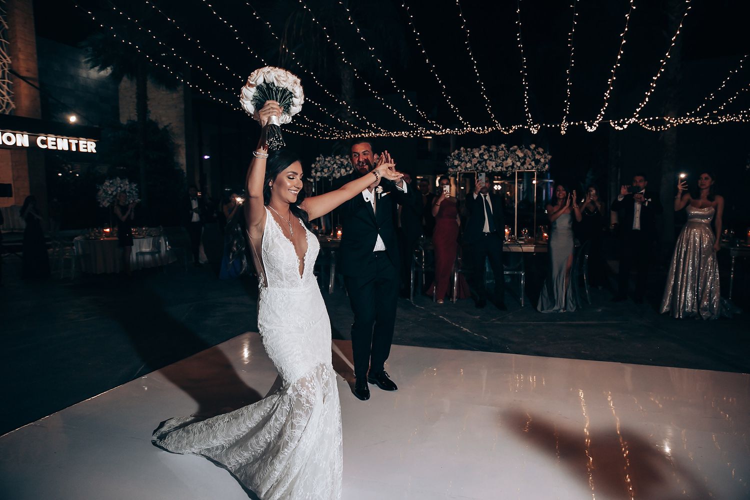 Wedding reception dance floor with twinkling lights and elegant decor overhead.